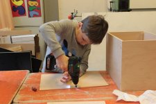 Familienworkshop Cajonbau und -spiel im Kulturfenster Heidelberg; Bild: Junge beim Bauen 